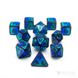 Metal dice with black numbers and borders with a blue and teal colored dragon scale pattern inlaid into each face